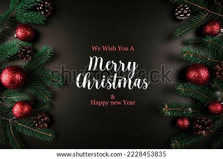 merry Christmas composition green fir tree branches with red baubles.letting merry Christmas and happy new year.