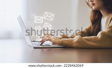 Email marketing and newsletter concept. Woman using computer laptop and sending online message with email icon Royalty-Free Stock Photo #2228462069