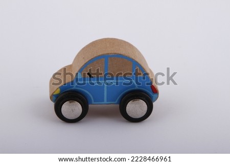 Plain simple wooden blue toy car against a white background