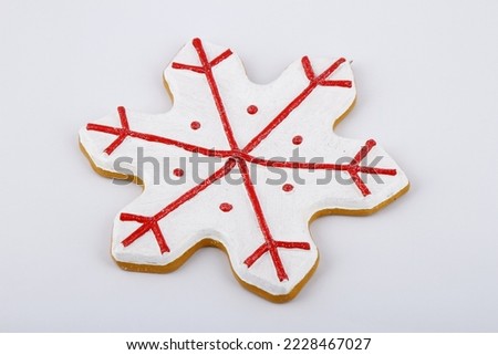 Red and white snowflake Christmas tree ornament on a white background