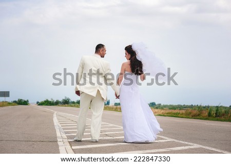 Beautiful loving couple bride and groom enjoying their wedding day outdoors on the road.