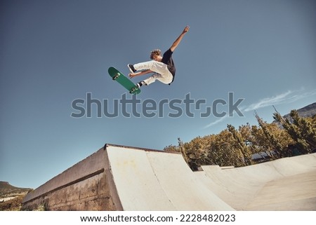 Sports, skateboarding and skater in air at park doing tricks, skating and having fun in urban town. Fitness, freedom and man do action skills, jumping and cool movement for sport, hobby and exercise Royalty-Free Stock Photo #2228482023