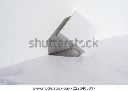 Two white square gift boxes mockup on gray concrete background. Closeup, shadows, minimalist concept Royalty-Free Stock Photo #2228485337