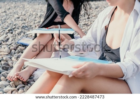 Unrecognizable woman's hands holding her own sea beach scenery watercolor painting. Amateur painter. Creative female artist drawing the picture at the beach. Art, creativity and inspiration concept.
