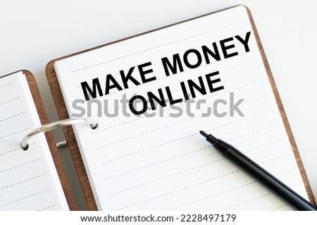 MAKE MONEY ONLINE text on an open notebook on the table, business concept