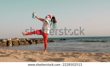 Santa Claus summer vacation. Father Christmas, having fun. Santa Claus doing yoga. Funny Santa, in sunglasses, with flippers and snorkeling mask, on beach by the sea. Santa going to snorkel. High
