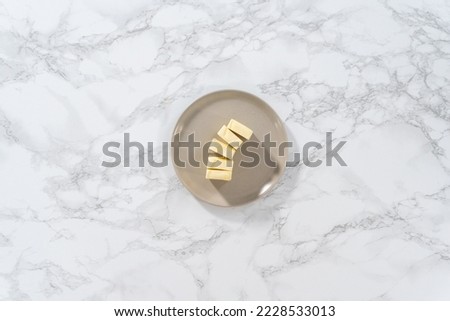 Flat lay. Softened sticks of unsalted butter on the kitchen counter. Royalty-Free Stock Photo #2228533013