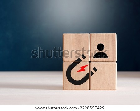 Lead generation, customer retention, inbound marketing or brand loyalty concepts. Male hand places wooden cubes with magnet attracting a customer icon. Royalty-Free Stock Photo #2228557429