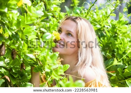 Portrait happy dreaming blonde young woman at summer outdoor greenery background with tropical green plants, looking up. Travel vacation tourism and leisure concept. Copy text space