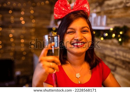 indian woman drinking alcohol at studio shot spruce Christmas tree lights garland background