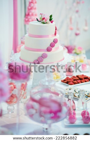 Pink and white wedding cake on a dessert table