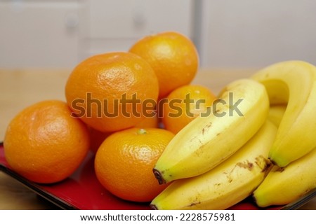 Mandarin oranges and bananas on a red plate