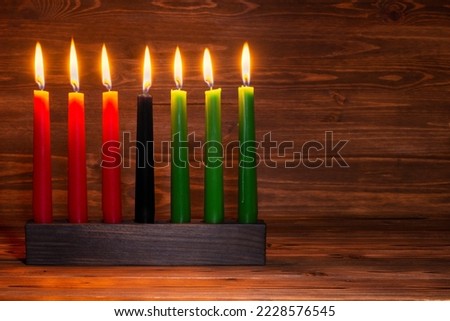 Kwanzaa festival concept with seven candles red, black and green in candlestick on wooden background, 