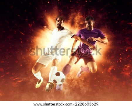 Two soccer player in action on fire background