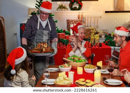 A family is celebrating christmas together. A young girl give her grand mother a gift for christmas.