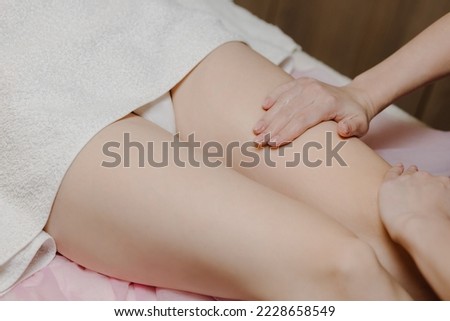 A female massage therapist gives an anti-cellulite massage to a young woman in a spa salon. Close-up view. High quality photo