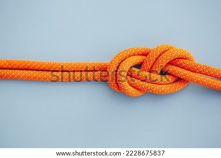 Eight knot on a rope on a blue background. Copy space