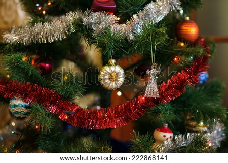 Christmas ball in shape of sunflower on Christmas tree. Christmas tree and light garland on background. Shallow depth of field. Focused on ball