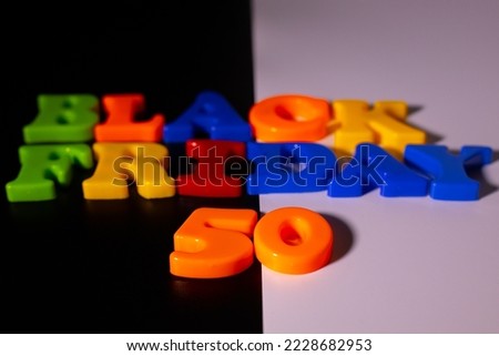 Plastic letters and the inscription Black Friday and 50 Discounts are placed on a black and white background.