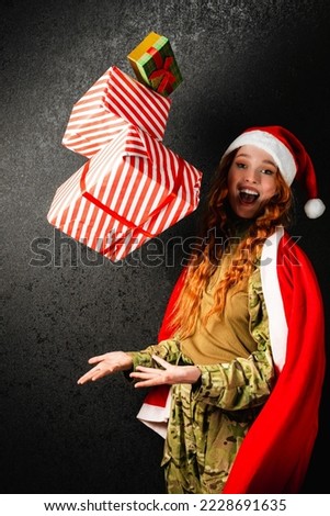 A red-haired woman in a red hat throws gifts boxes. Portrait happy girl in a military army uniform on a black dark background. The concept of Christmas and New Year.