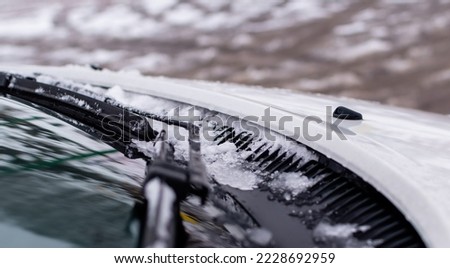 Windshield wiper blades close-up with ice on blurred winter background Royalty-Free Stock Photo #2228692959