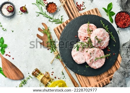 Raw burger patty. Caul-Fat Meatballs cutlet handmade. On a gray stone background. Top view.