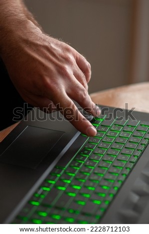 Close-up of a man's hand typing on a keyboard.