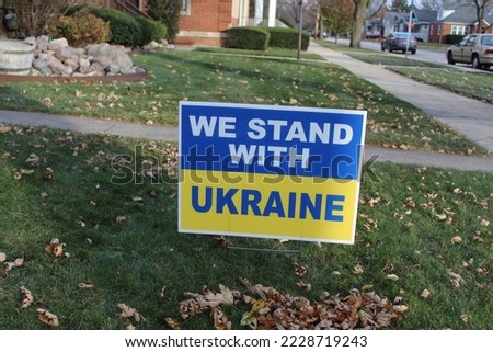 We Stand With Ukraine yard sign with fallen leaves in front of it in Des Plaines, Illinois