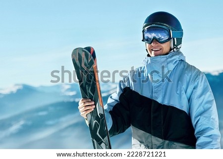 Portrait of a skier in the ski resort on the background of mountains and blue sky, Bukovel.  Ski goggles of a man wearing ski glasses. Winter Sports