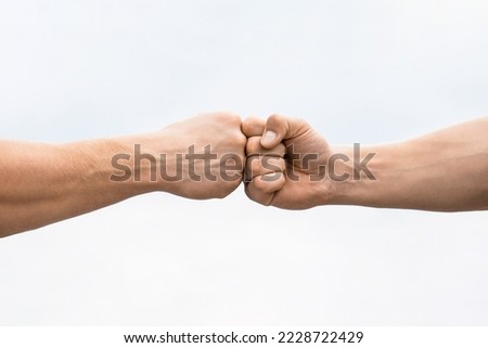 Teamwork and friendship. Partnership concept. Man giving fist bump. Bumping fists together. Fist Bump. Clash of two fists. Concept of confrontation, competition. Gesture of giving respect or approval. Royalty-Free Stock Photo #2228722429