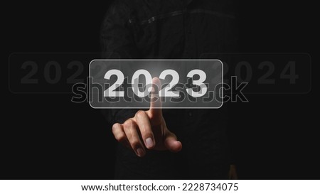 Choosing the new fiscal year 2023. The male hand chooses the new 2023 year. Choosing a new year and new business goals