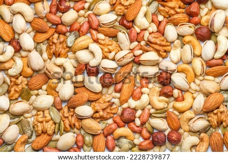 Background from different types of nuts and seeds - peeled walnut, hazelnuts, peeled peanut, pine nut kernels, almond seeds, cashew seeds, pistachio nuts in the shell, pumpkin seeds Royalty-Free Stock Photo #2228739877