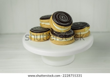 Round cakes covered in dark chocolate with white filling