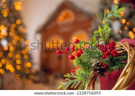 Christmas red pine tree with background bokeh light gingerbread house, New Year sign copy space sunlight.