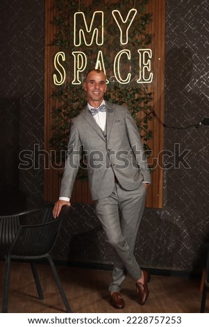 Confident business man in an elegant suit in a photo session with beautiful lighting cafe decoration