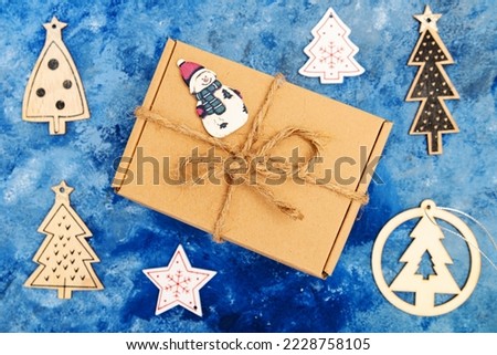 Christmas composition. Christmas decorations. Gift in box on blue background. View from above.