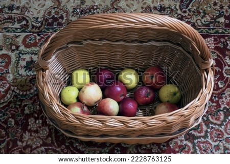 Fresh homemade apples in a wicker basket on a carpet