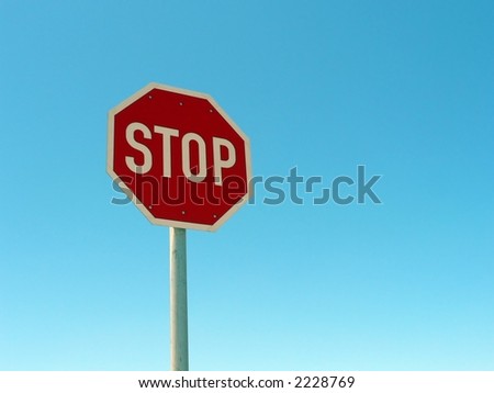 Road stop sign against a blue sky.