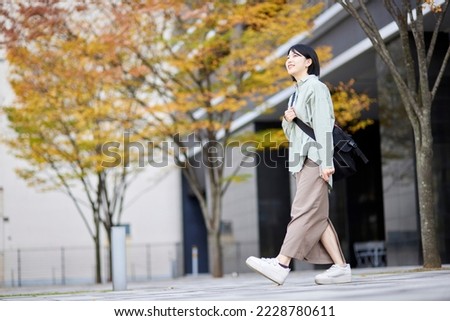 Young Japanese college student enjoying campus life Royalty-Free Stock Photo #2228780611