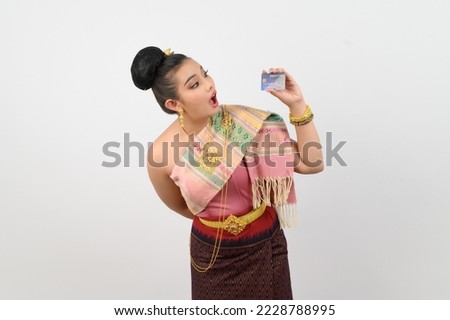 Portrait of Young woman in Thai Northern Traditional Clothing with credit card, Pretty Asian woman in beautiful dress payment by credit card on white background