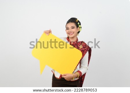 portrait Young pretty woman dress up in beautiful local culture in northeastern region, she holding blank yellow speech bubble sign with exciting on white background, copy space