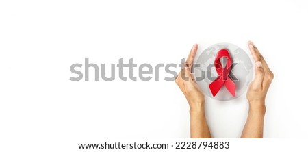 Hand covered 3d red ribbon on world map background, campaign for World AIDS Day on 1 December