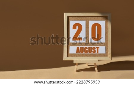 August 20th. Day 20 of month, Calendar date. Cork board, easel in sunlight on desktop. Close-up, brown background.  Summer month, day of year concept.