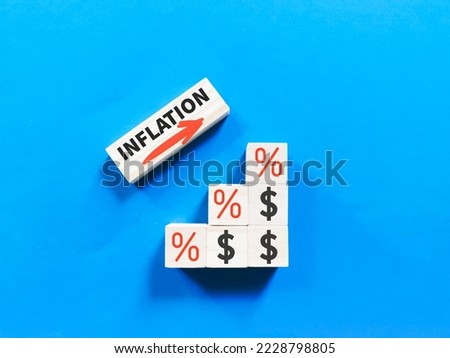 Inflation rising on wooden cubes with icons against blue background.