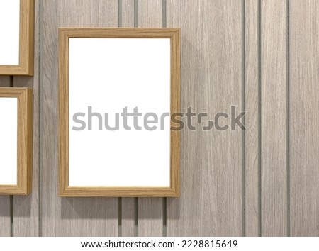 Empty wooden picture frame Hanging on a modern wooden wall.