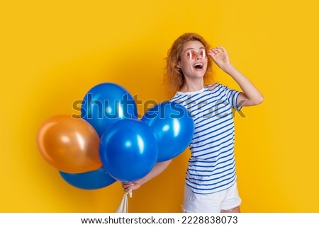party girl with balloon in sunglasses. caucasian girl hold party balloons in studio