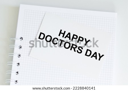 Happy Doctor's Day text on a card on a background of blonde on the table, business concentration