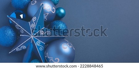 Christmas decorations on blue background. Christmas or New year composition in monochrome dark blue colors. Top view, flat lay, copy space, banner