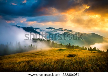 Amazing mountain landscape with fog and a haystack Royalty-Free Stock Photo #222886051