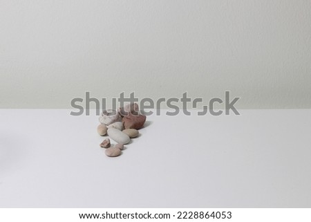 photo of white table decorated with magnificent stones of the sea, white background and vintage wall
